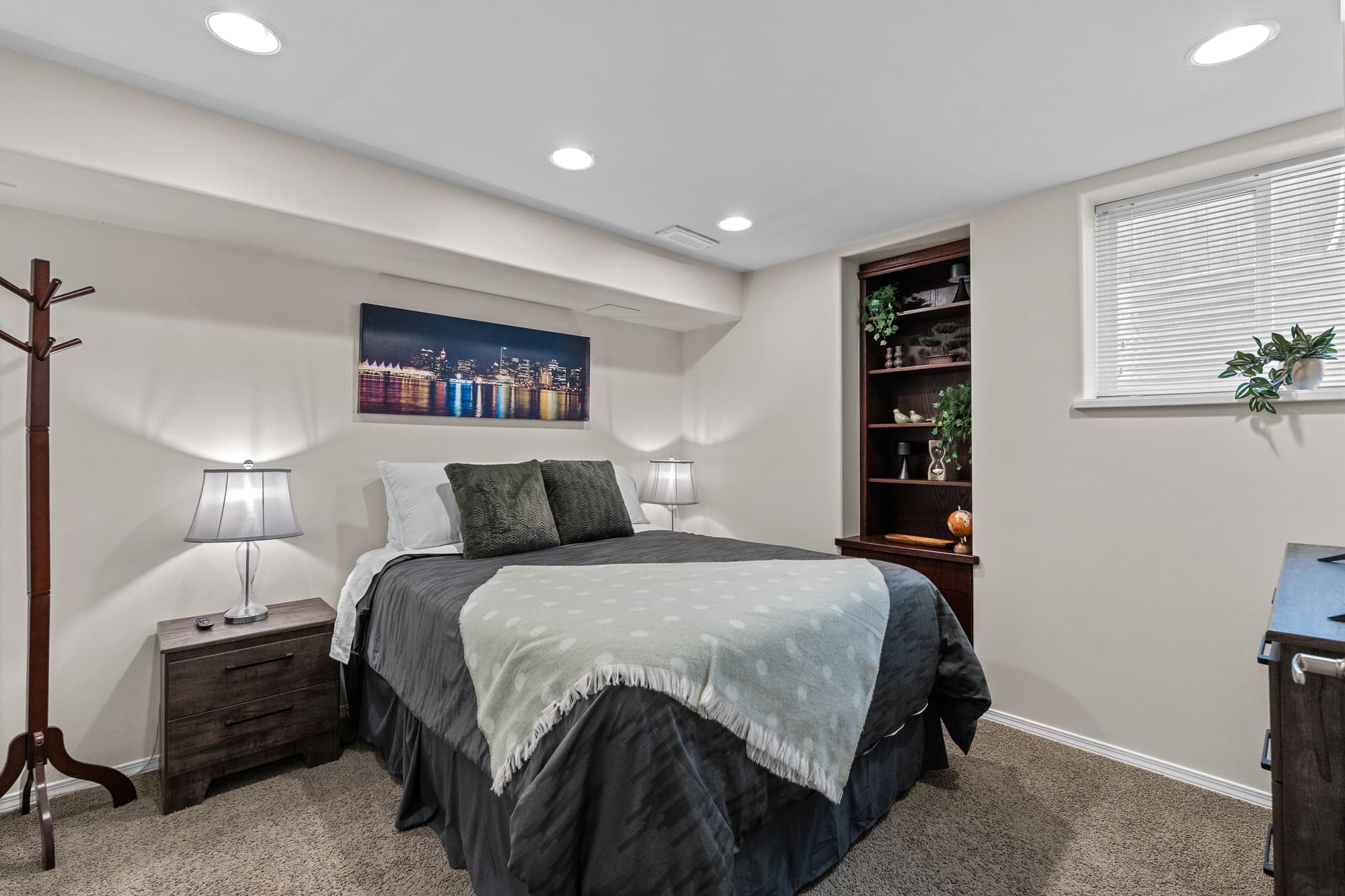 Primary bedroom with built-in shelving and city-print artwork