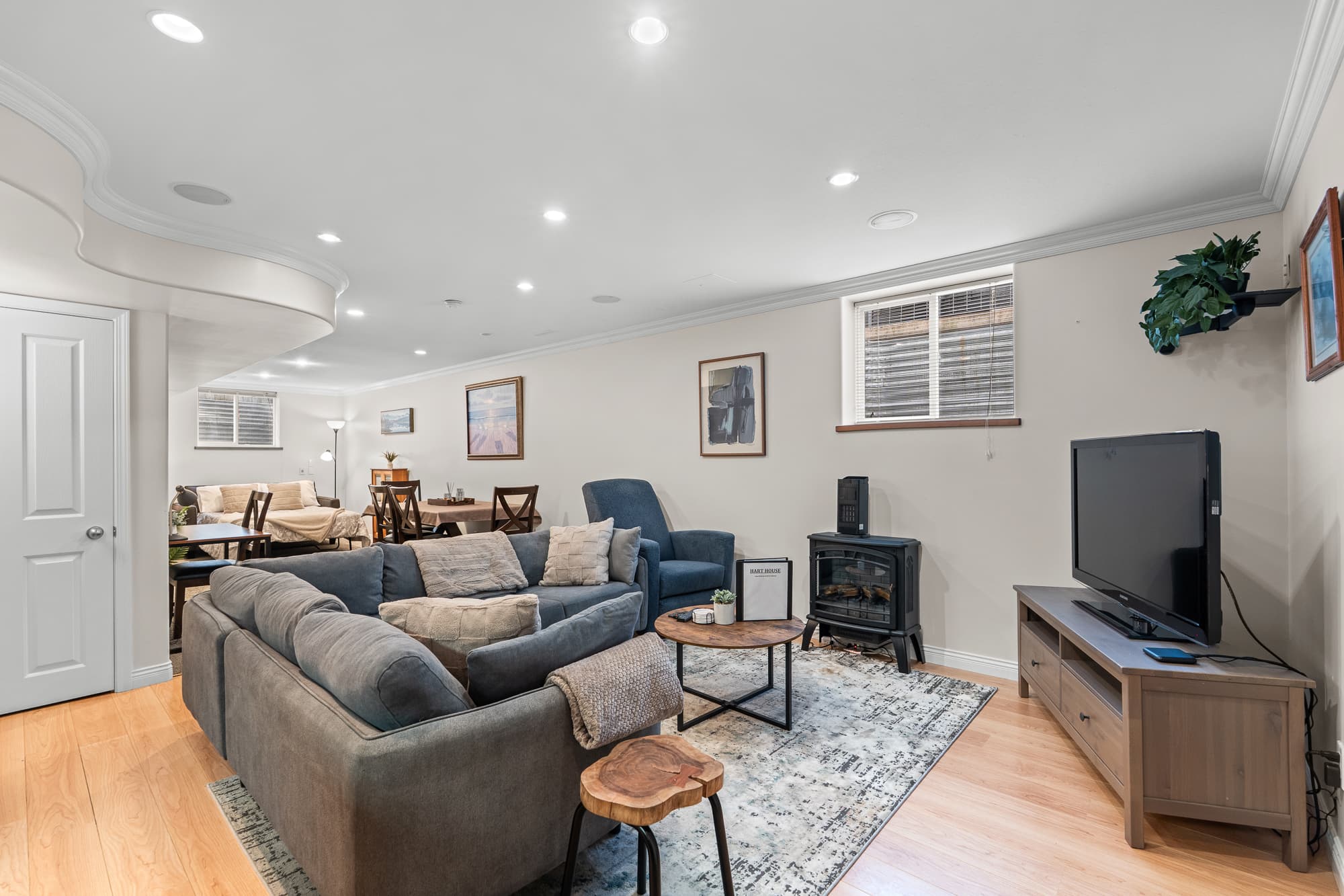 Spacious, professionally styled living area with sectional sofa and entertainment unit